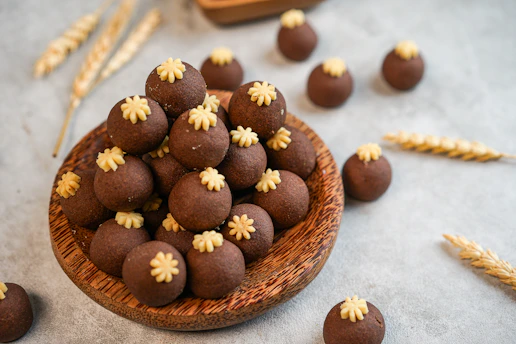 A wooden bowl filled with chocolate candies on top of a table