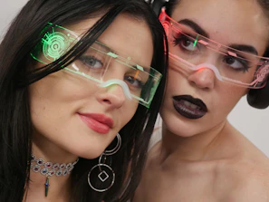 Two women with glasses on their faces posing for a picture