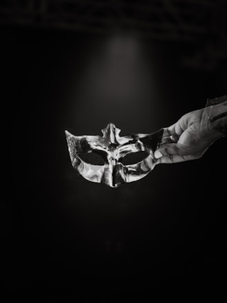 A black and white photo of a person holding a mask