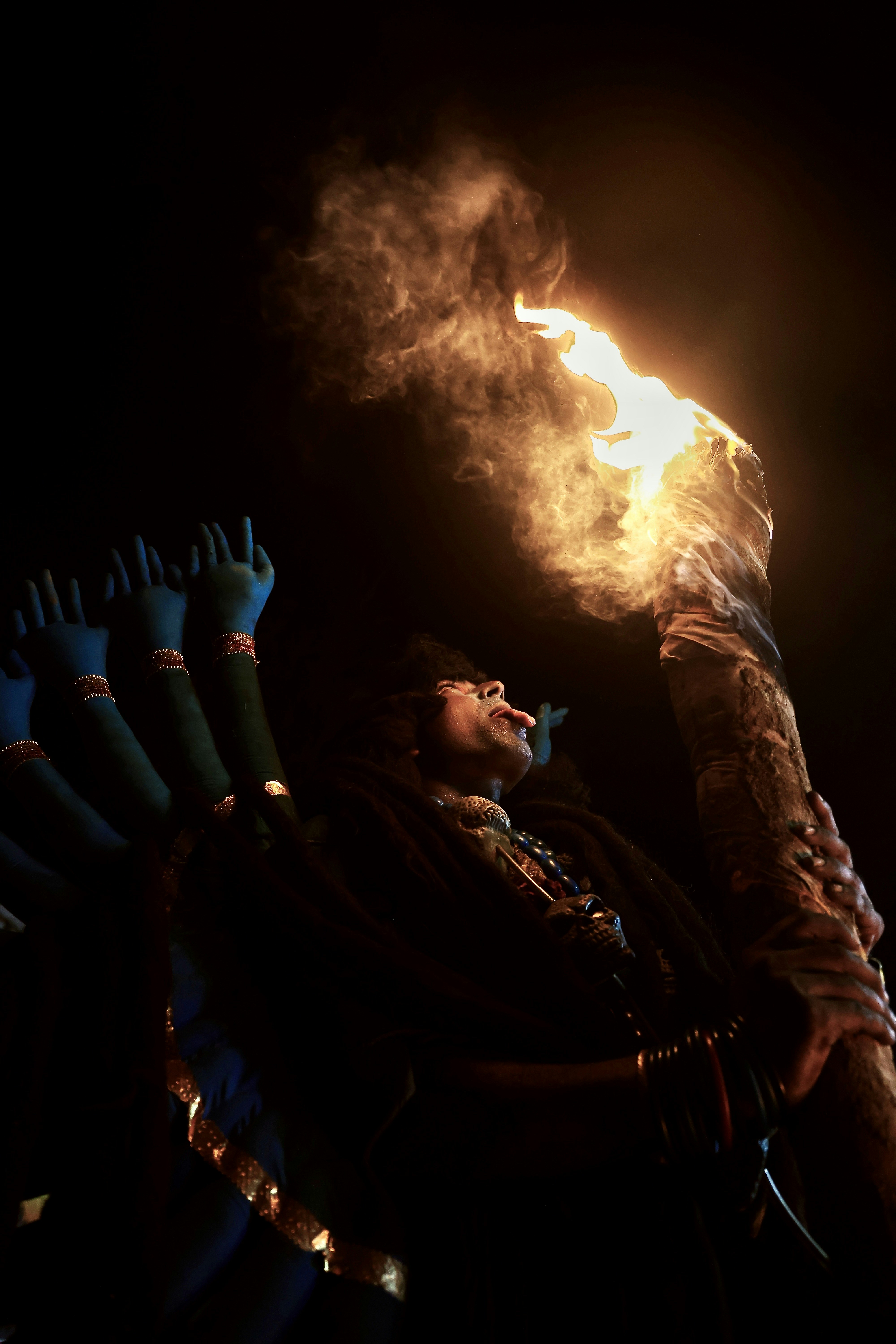 A man holding a bunch of brushes in his hand