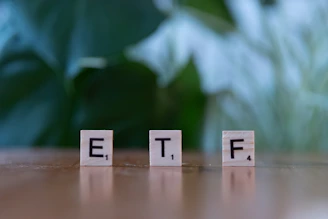 A wooden block spelling the word etf on a table