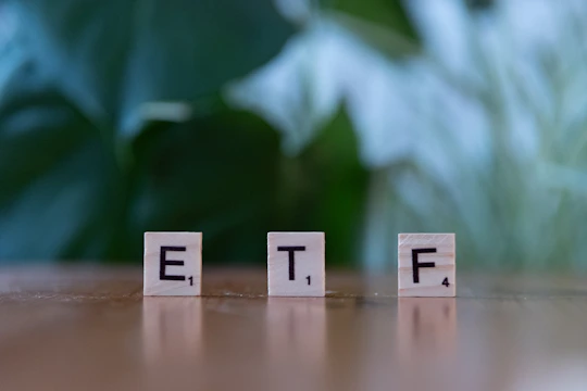 A wooden block spelling the word etf on a table