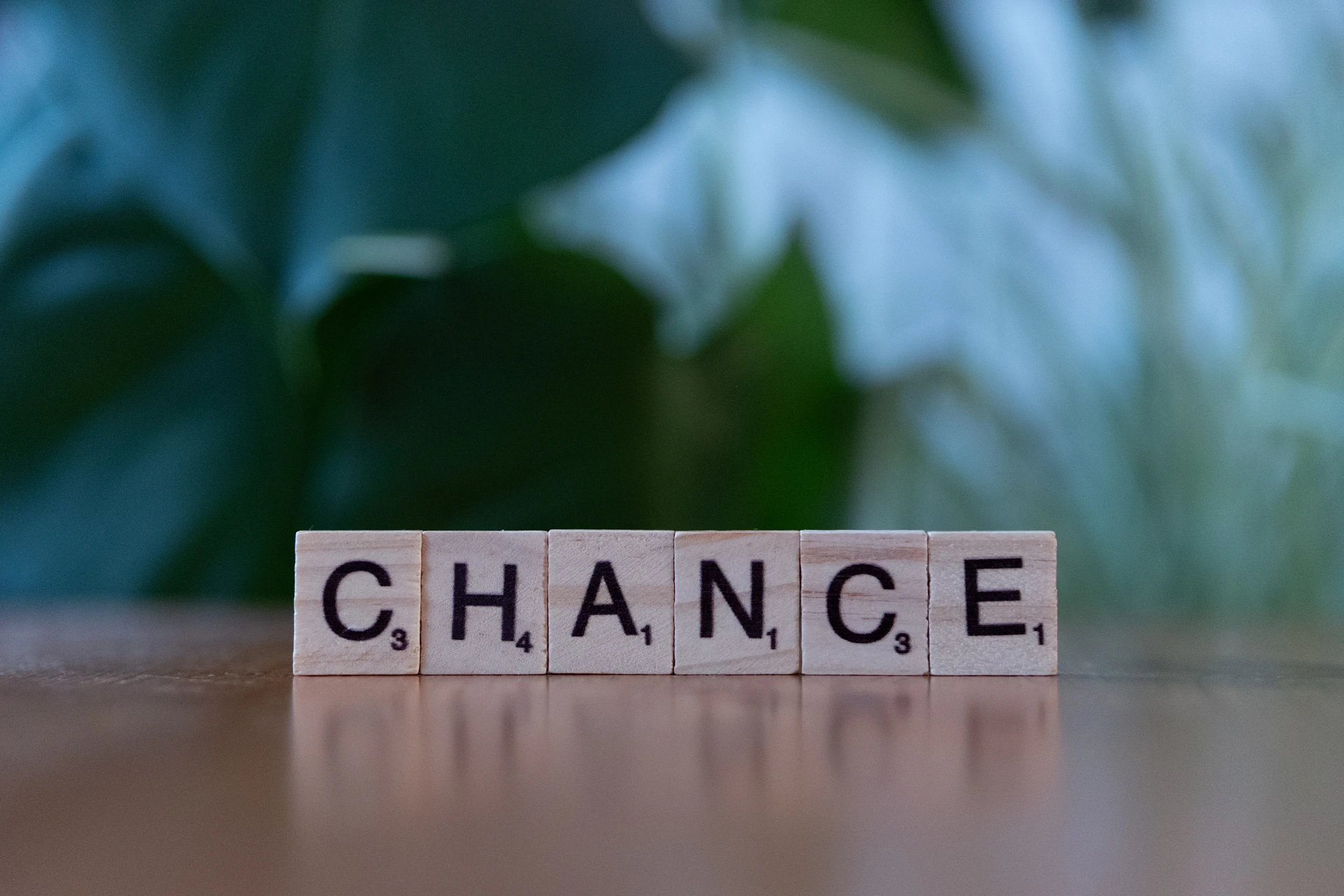 A scrabble block spelling the word chance on a table