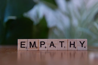 A wooden block spelling the word empathhy on a table