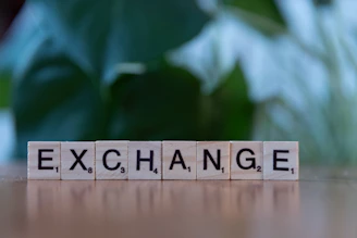 A scrabble block spelling the word exchange on a table