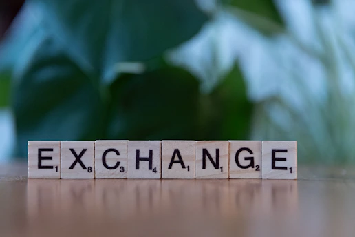 A scrabble block spelling the word exchange on a table
