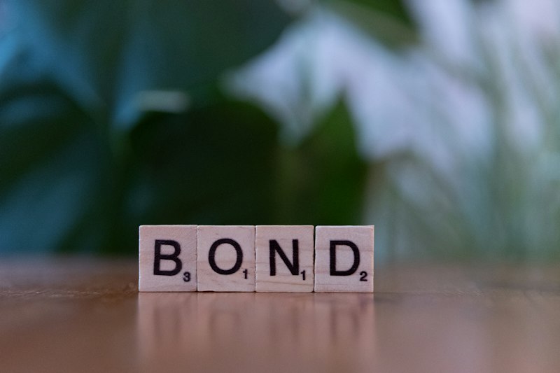 The word bond spelled with scrabble blocks on a table