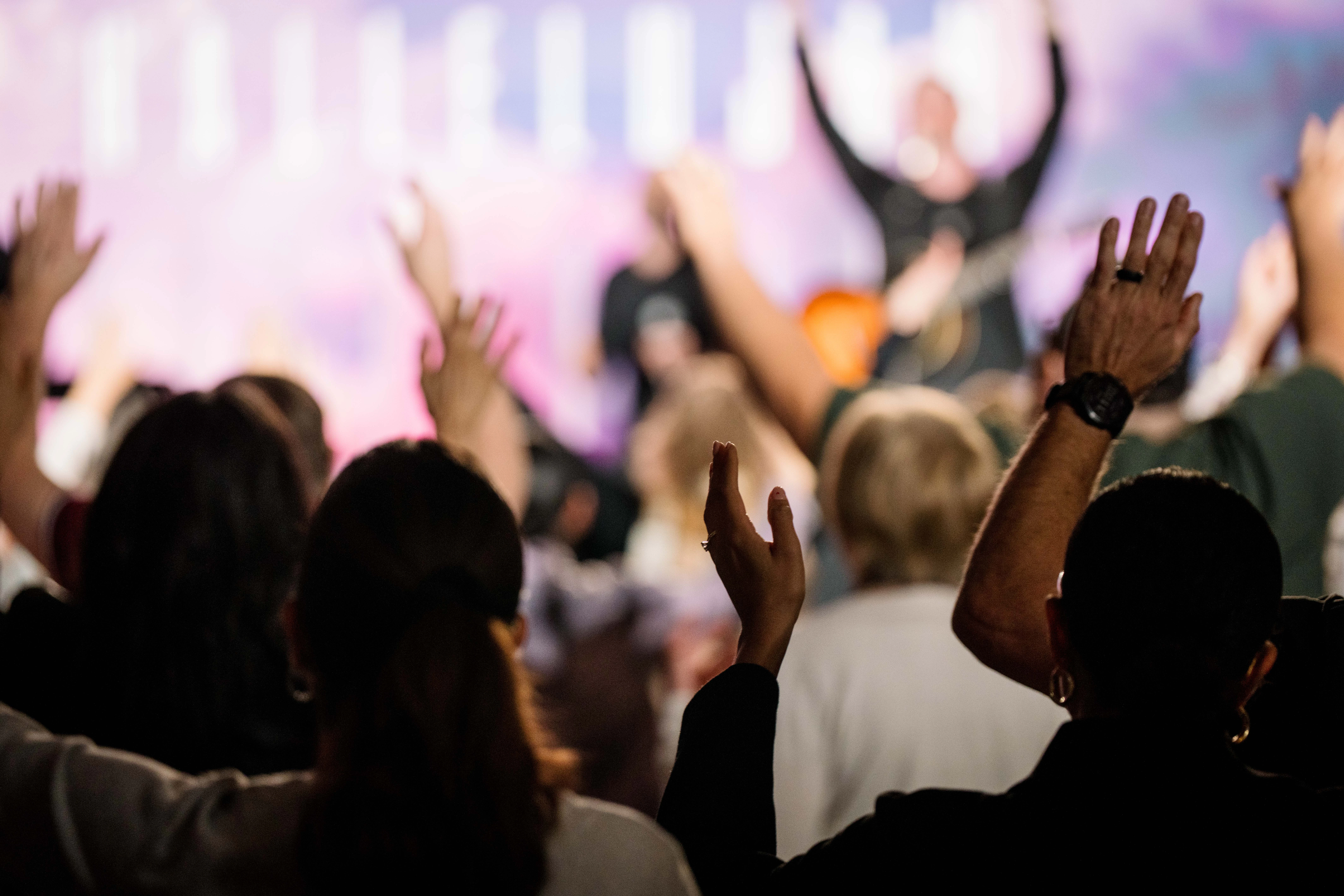Congregation worshipping together with hands raised