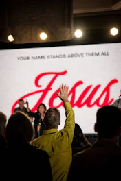 A group of people standing in front of a large screen