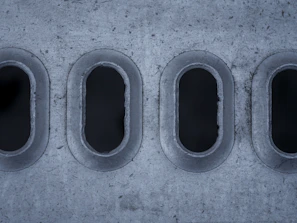 A cement wall with four round windows in it