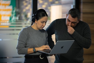 A man and a woman looking at a laptop