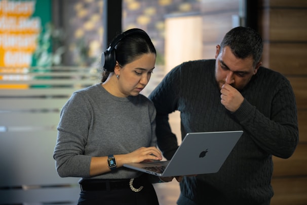 A man and a woman looking at a laptop