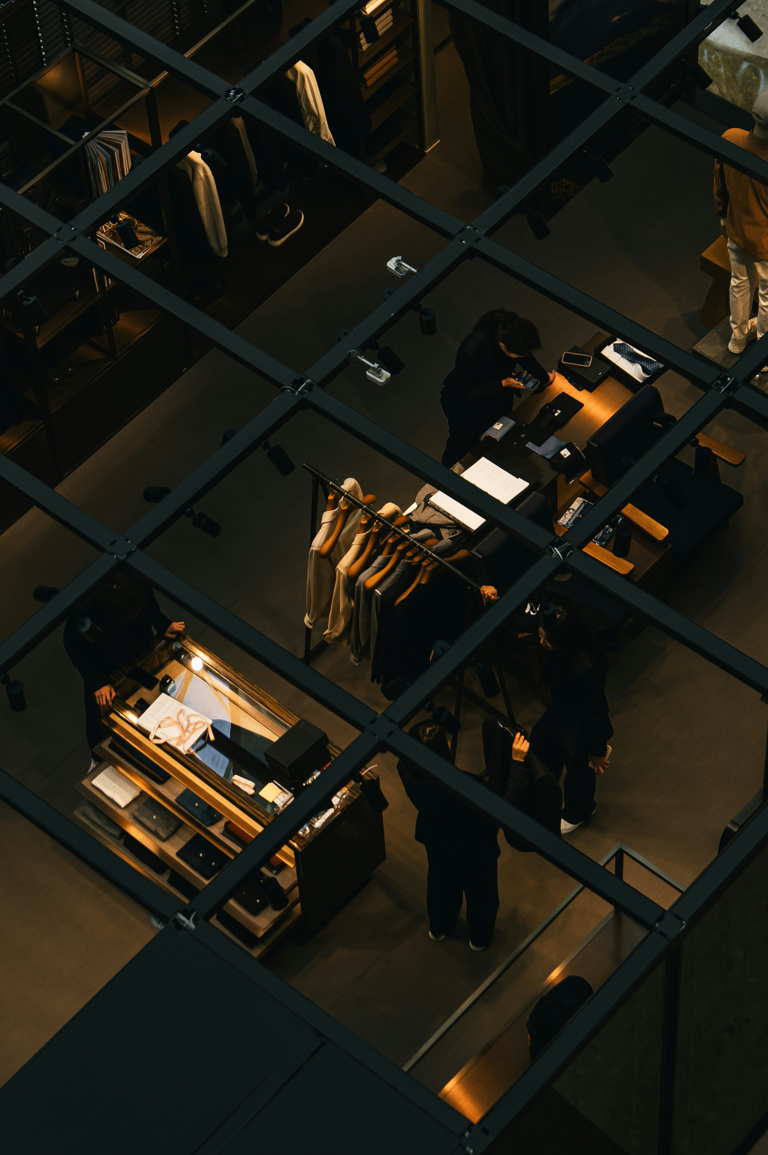 Customers browse merchandise in a modern clothing retail store.