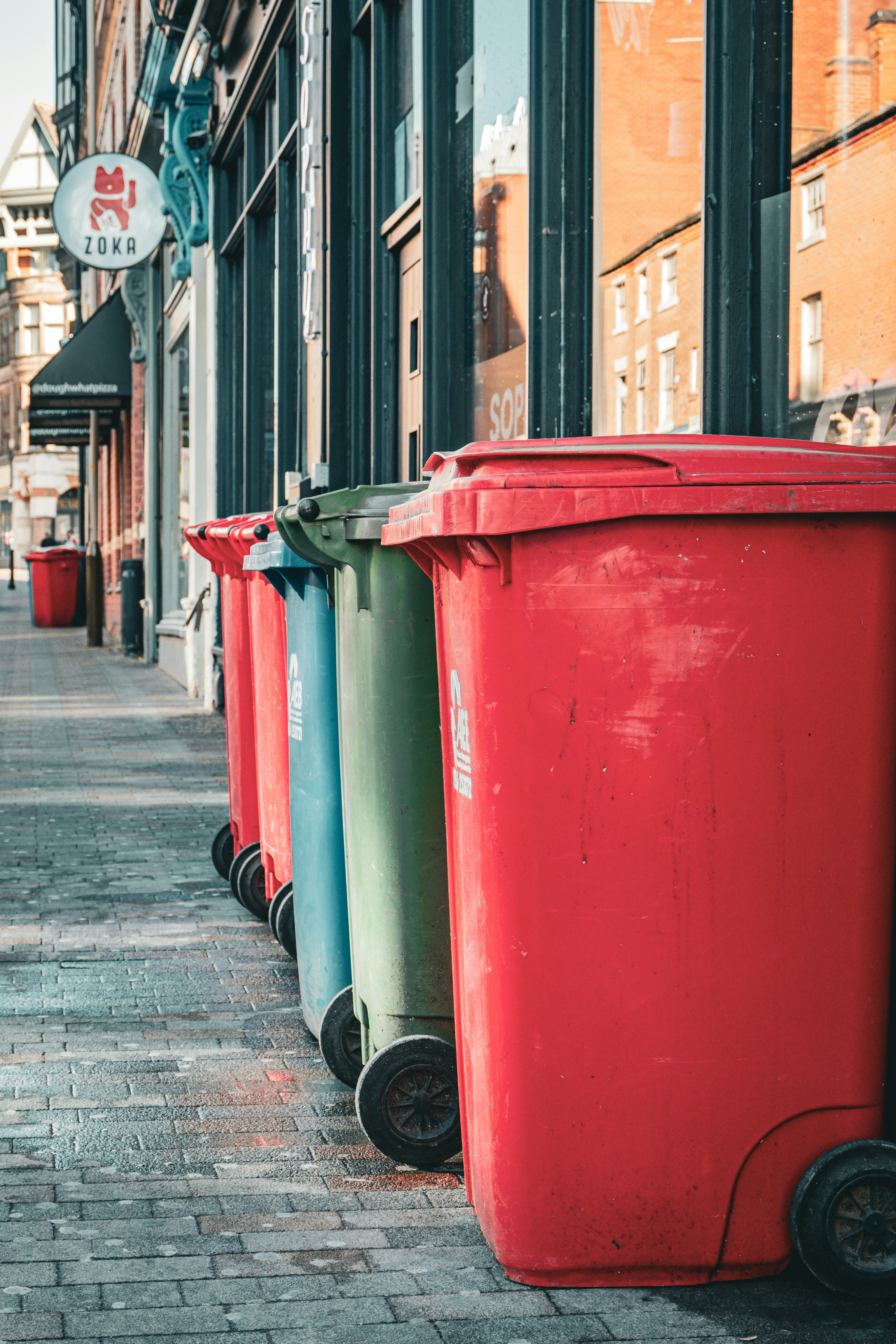 A row of trash cans sitting on the side of a street photo – Free City ...