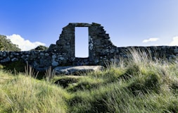 A stone building sitting on top of a lush green hillside