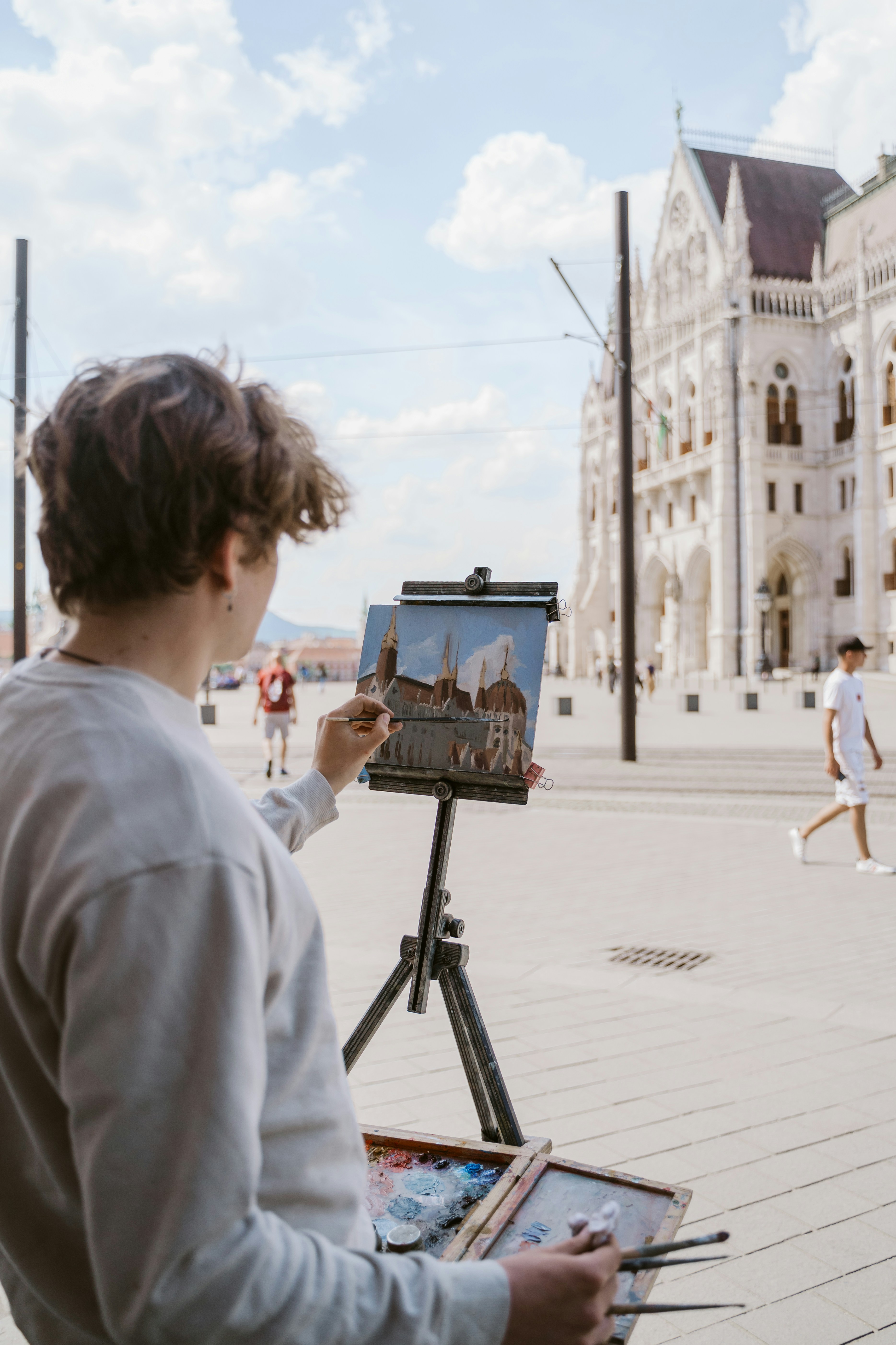 Um homem está pintando um quadro em um cavalete