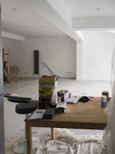 A room that has a table and a refrigerator in it