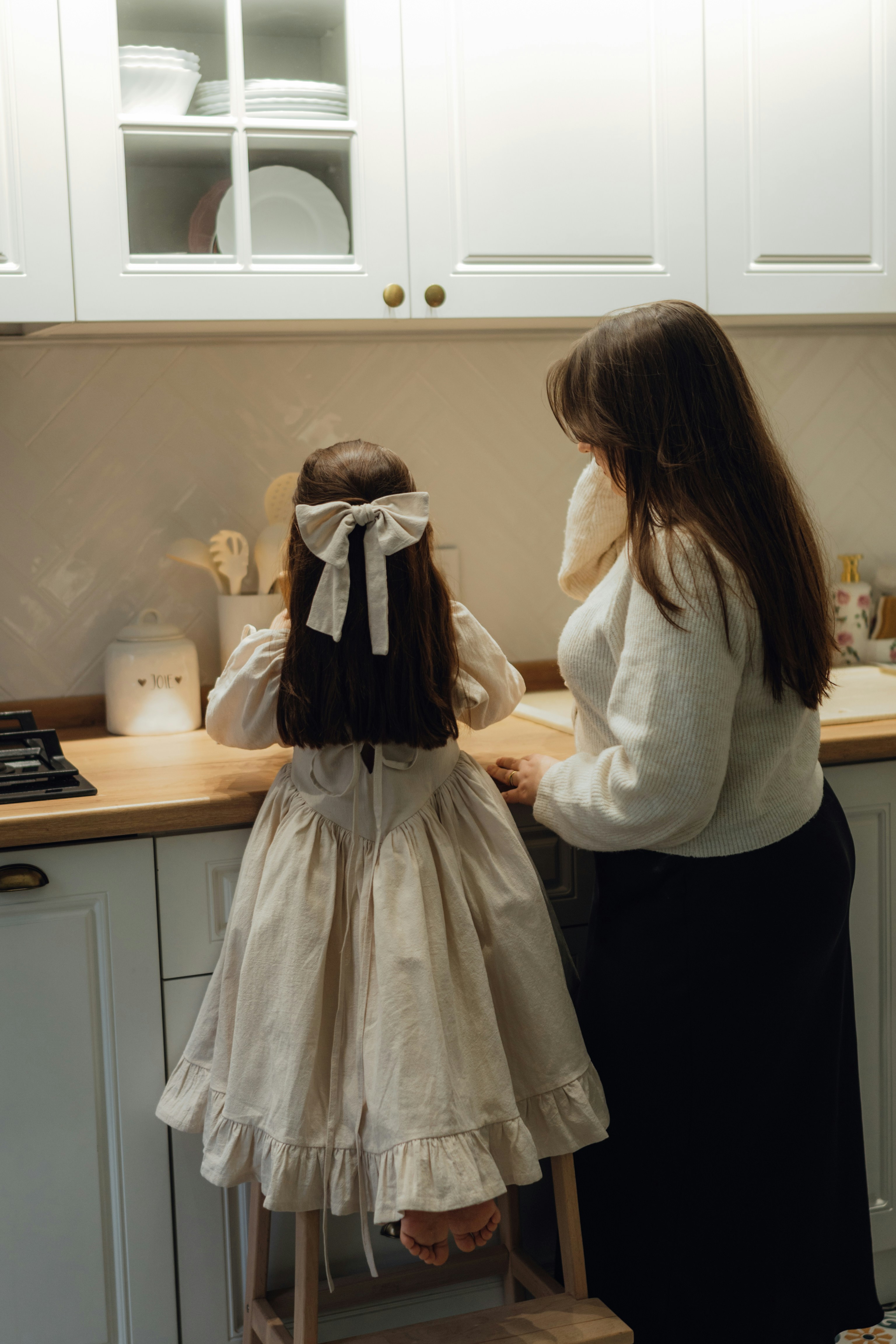 A woman and a little girl standing in a kitchen