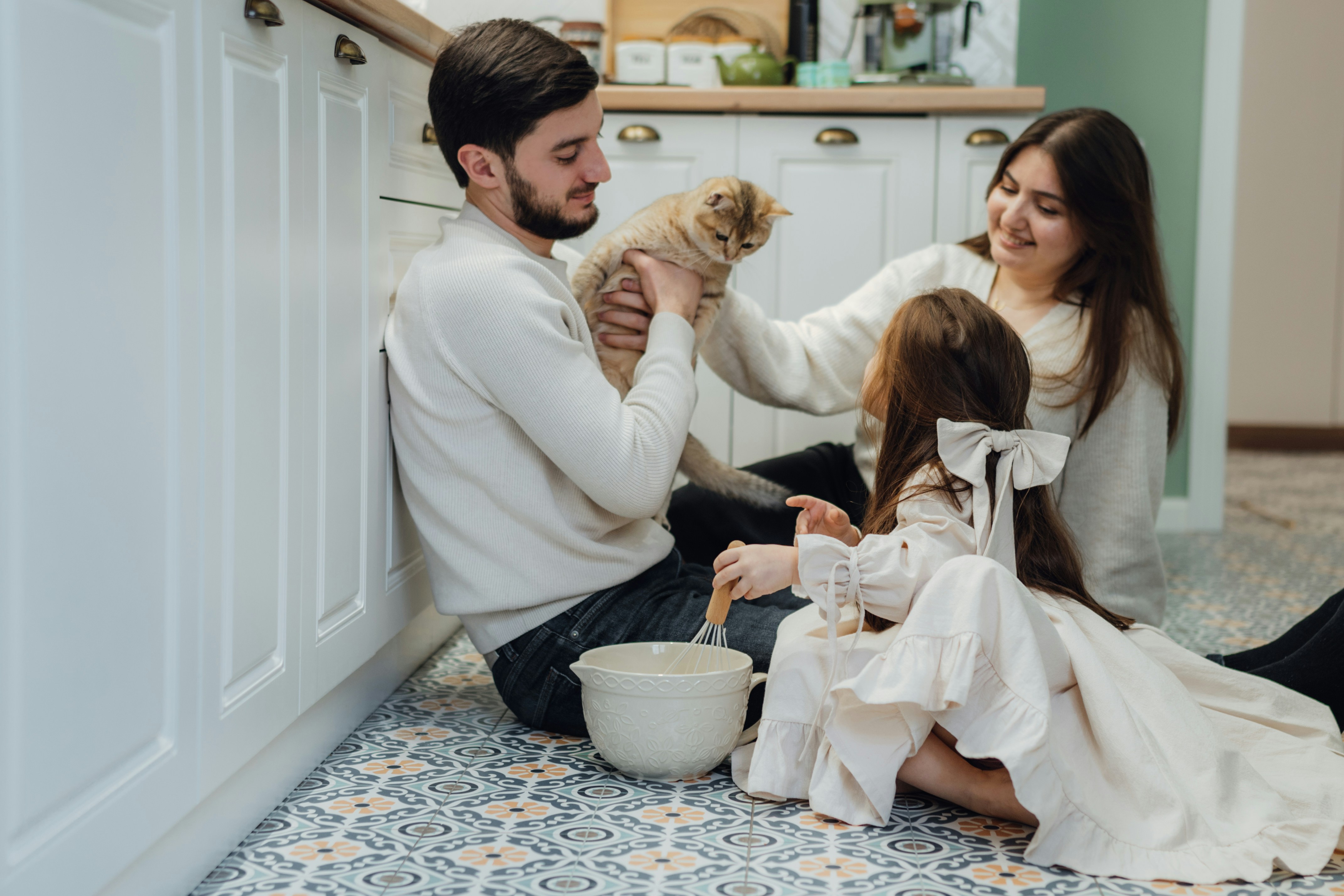 A man and a woman sitting on the floor with a dog