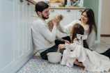 A man and a woman sitting on the floor with a dog