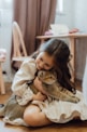 A little girl hugging a cat on the floor