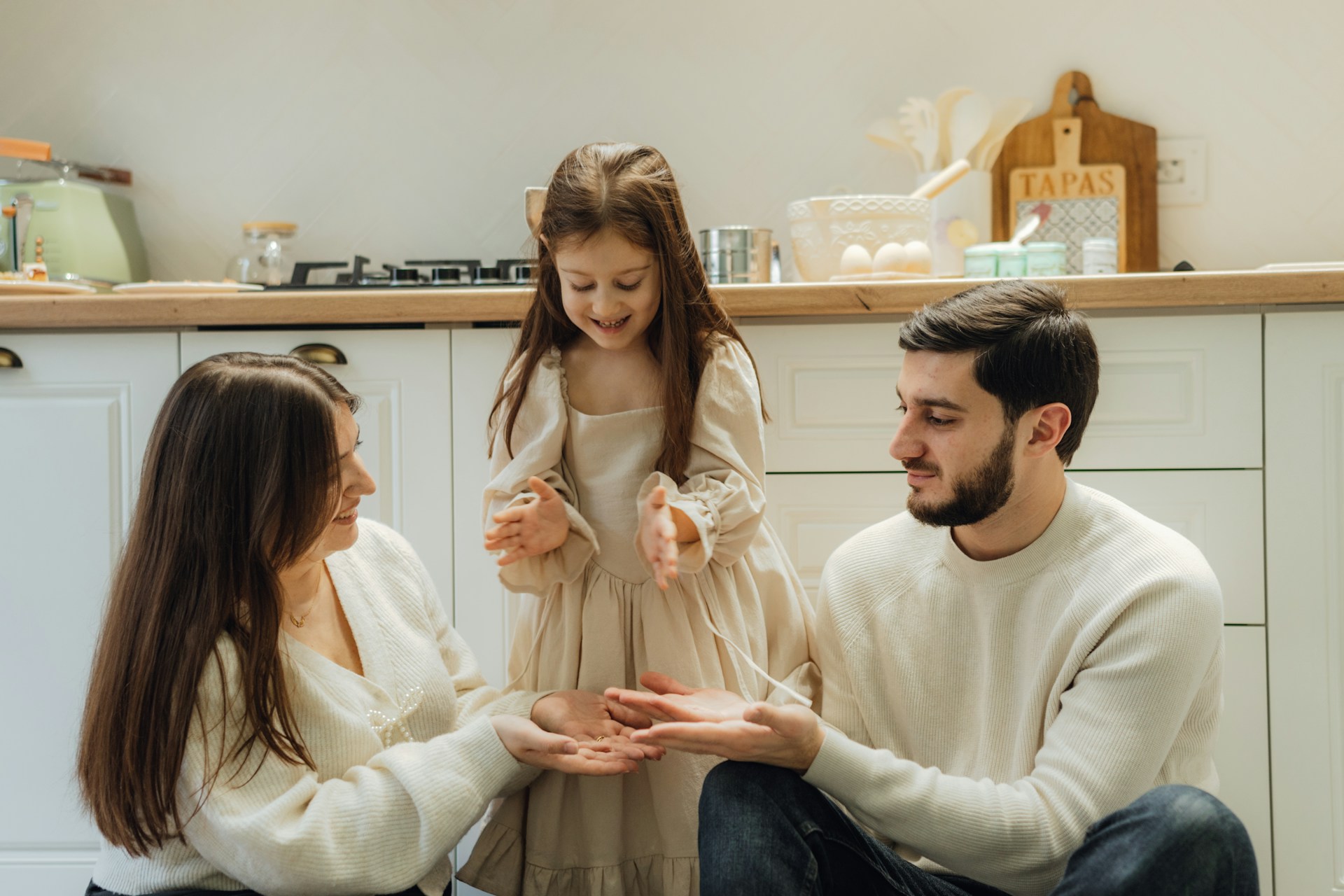 A group of people sitting around in a kitchen