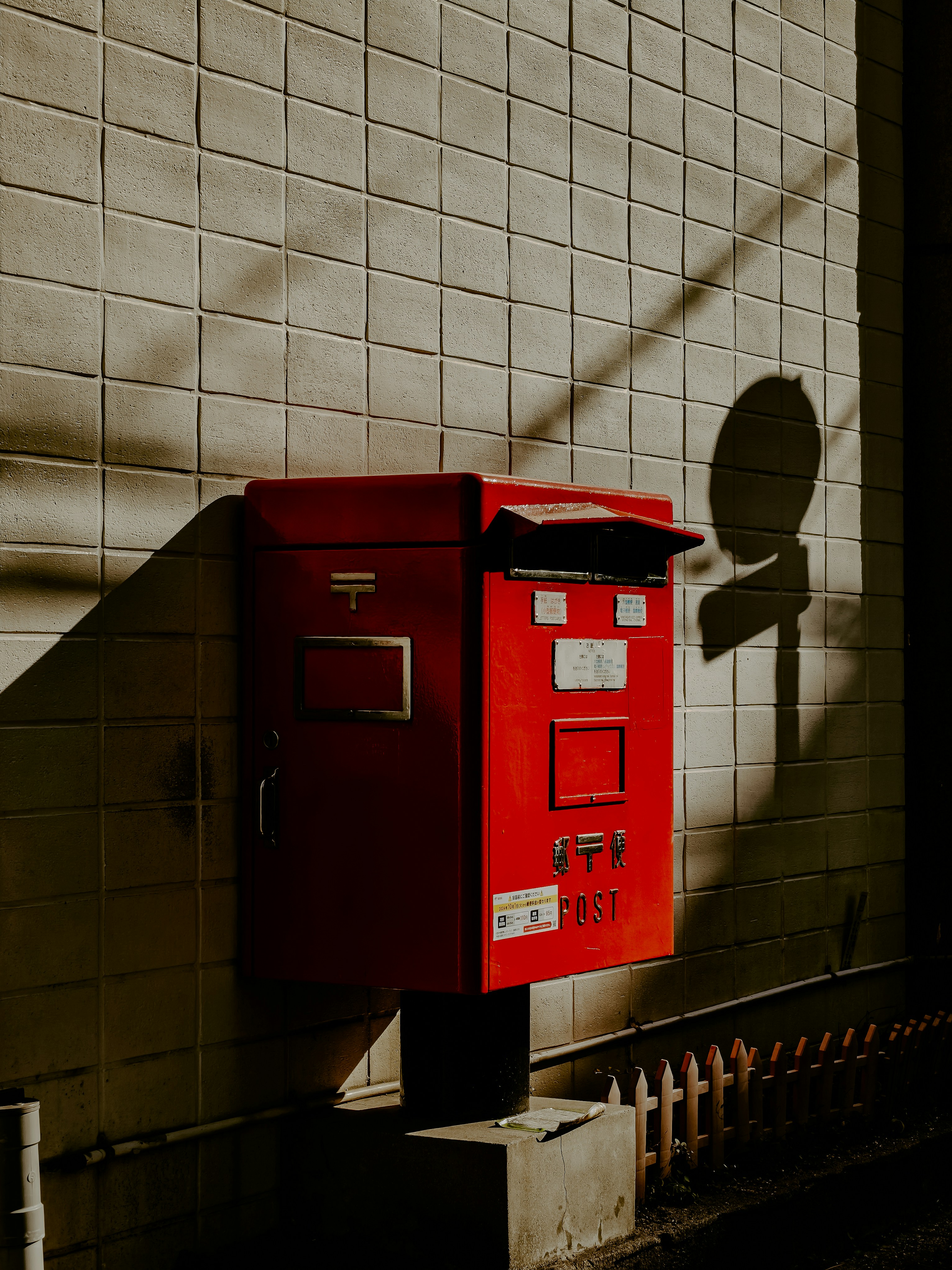 A red mailbox sitting on the side of a building