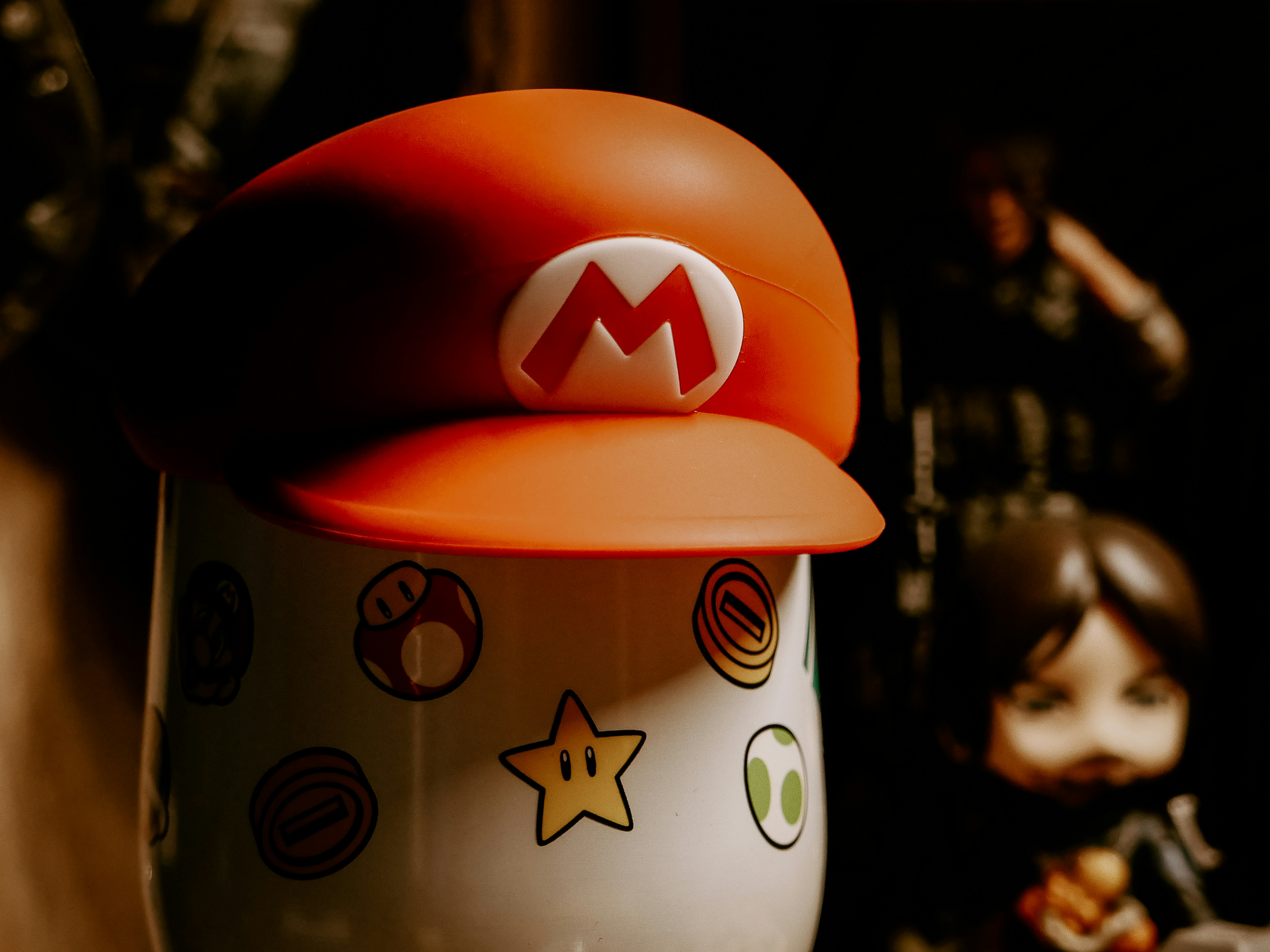 A close up of a cup with a mario hat on top of it