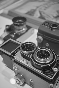 A couple of cameras sitting on top of a table