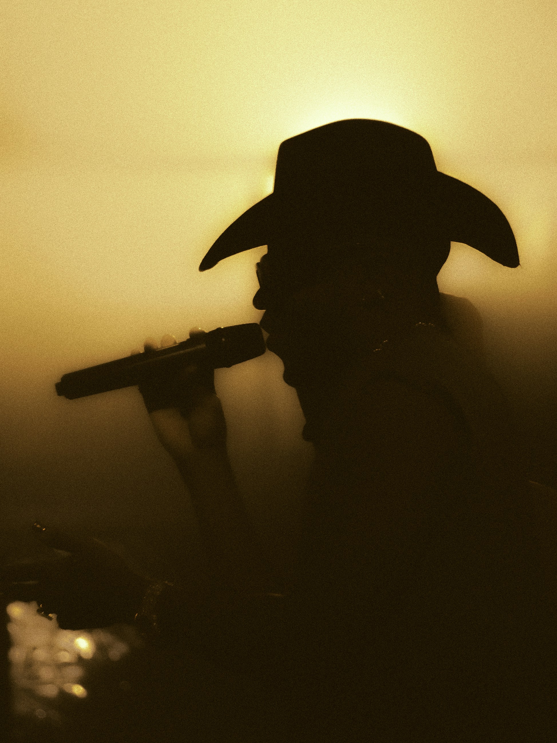 A silhouette of a man with a cowboy hat