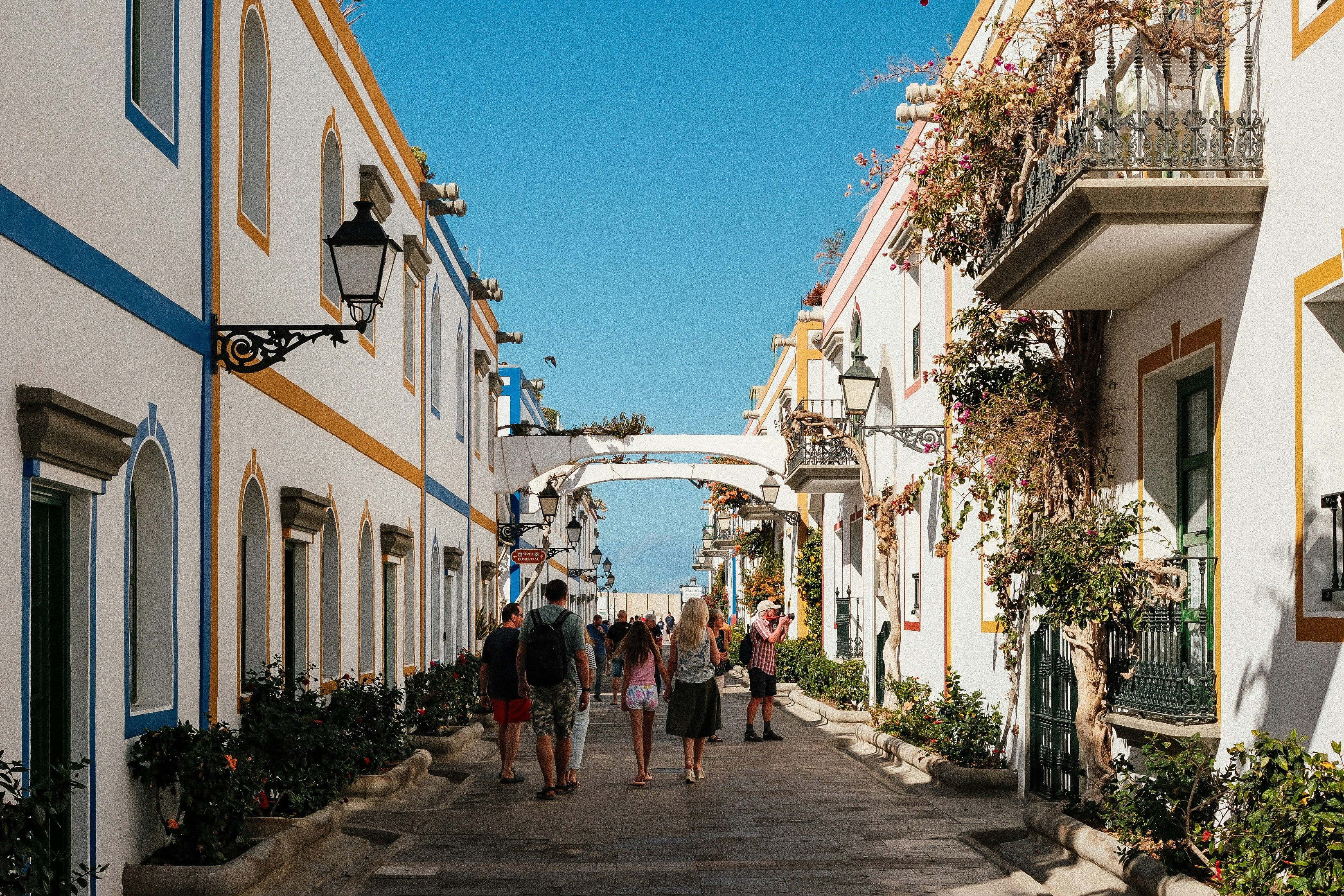 A group of people walking down a street next to tall buildings