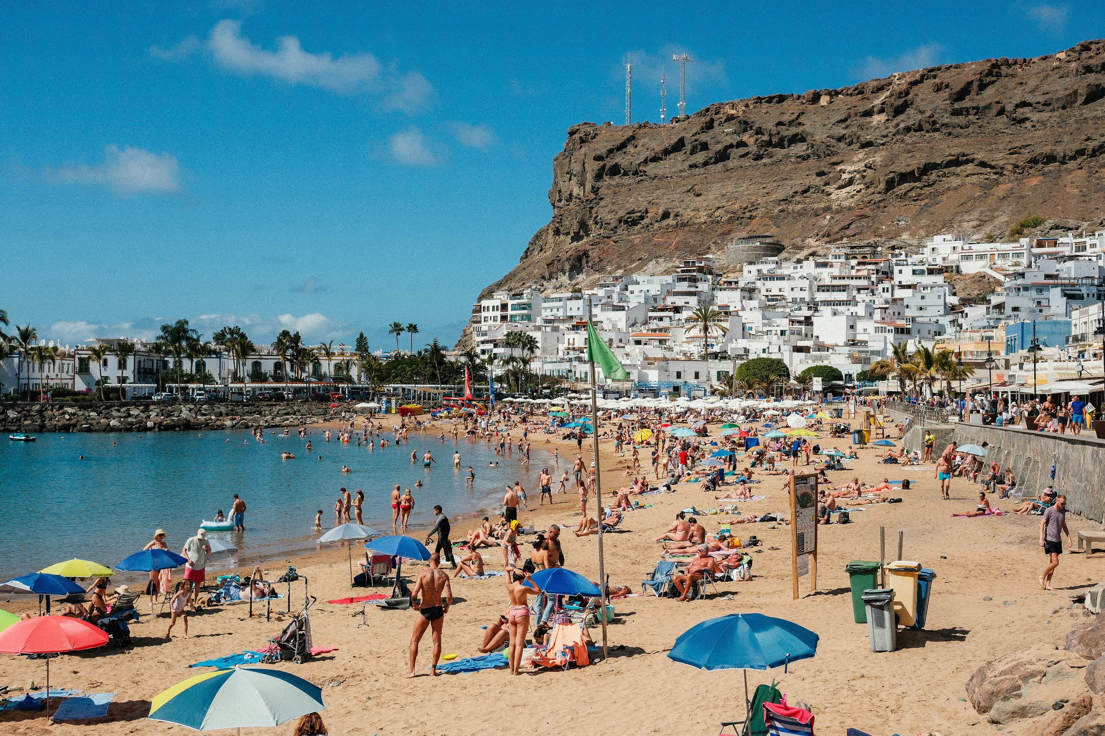 A crowded beach with many people and umbrellas