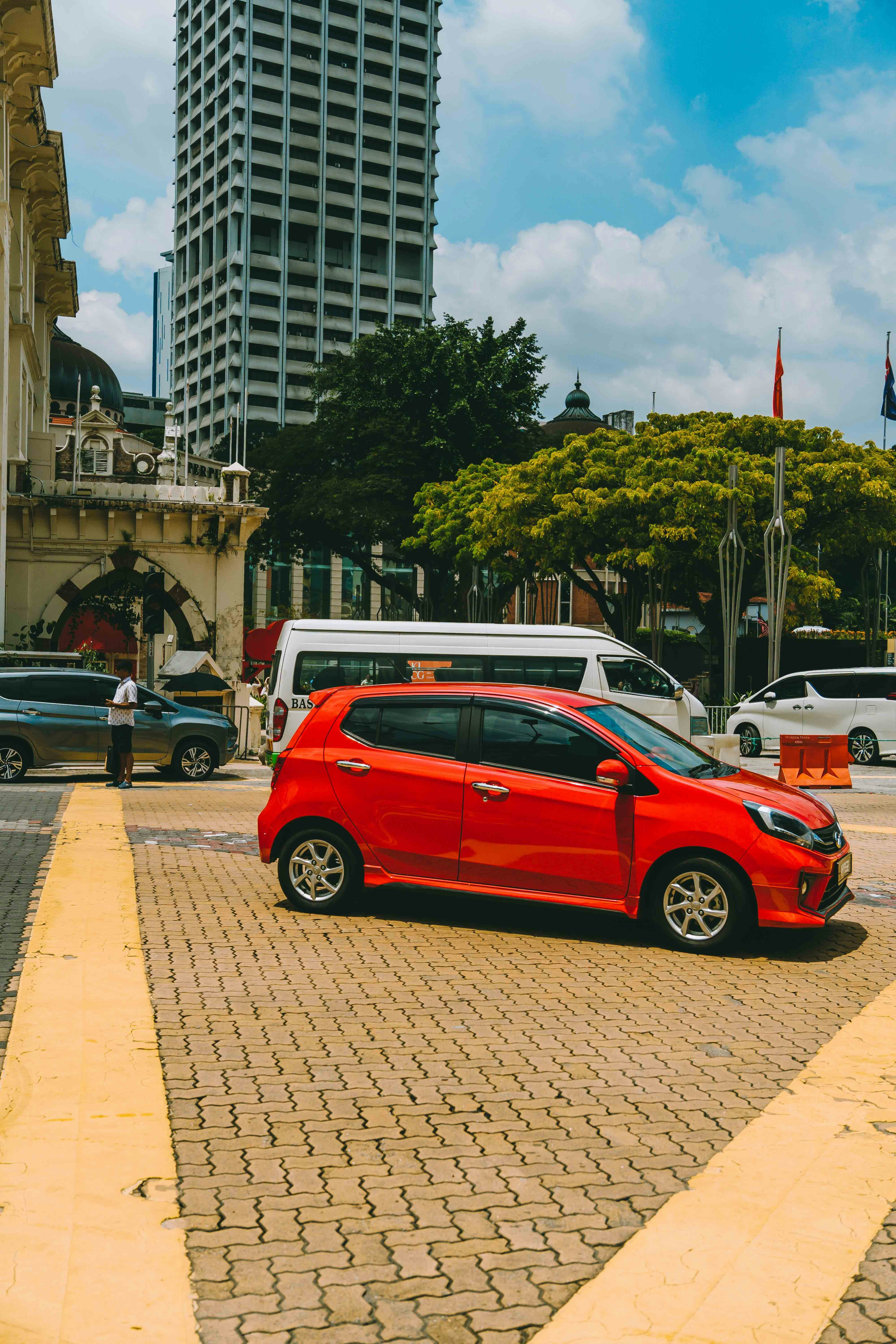 A red car is parked on the side of the road