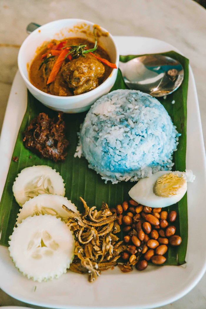Malaysisches Gericht mit Reis, Ei und Sambal auf einem Bananenblatt