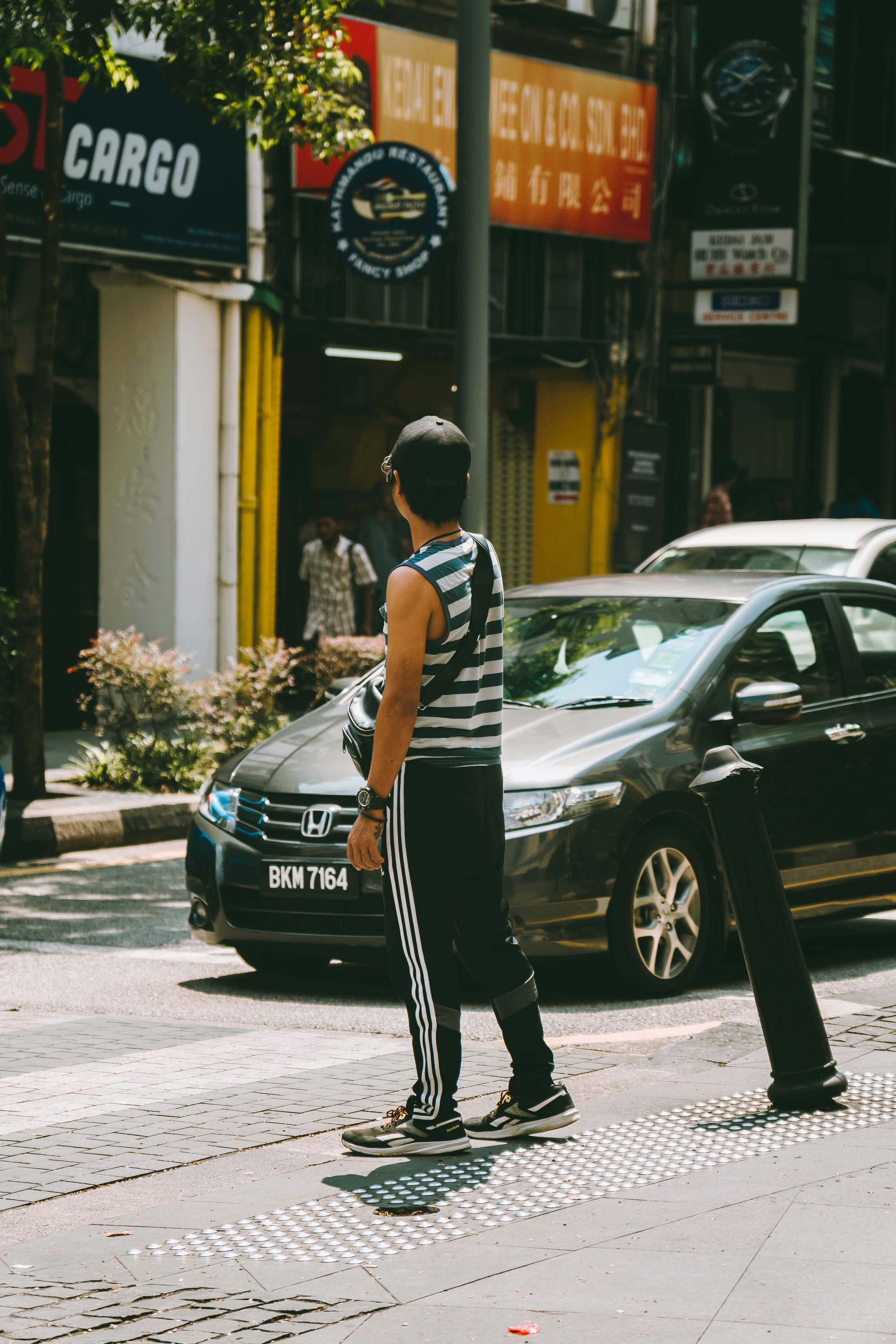 Professional chauffeur standing next to a taxi