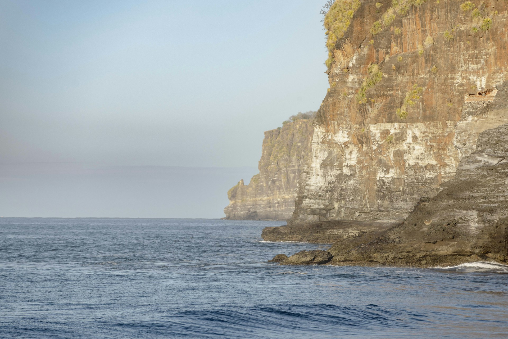 A large body of water next to a rocky cliff