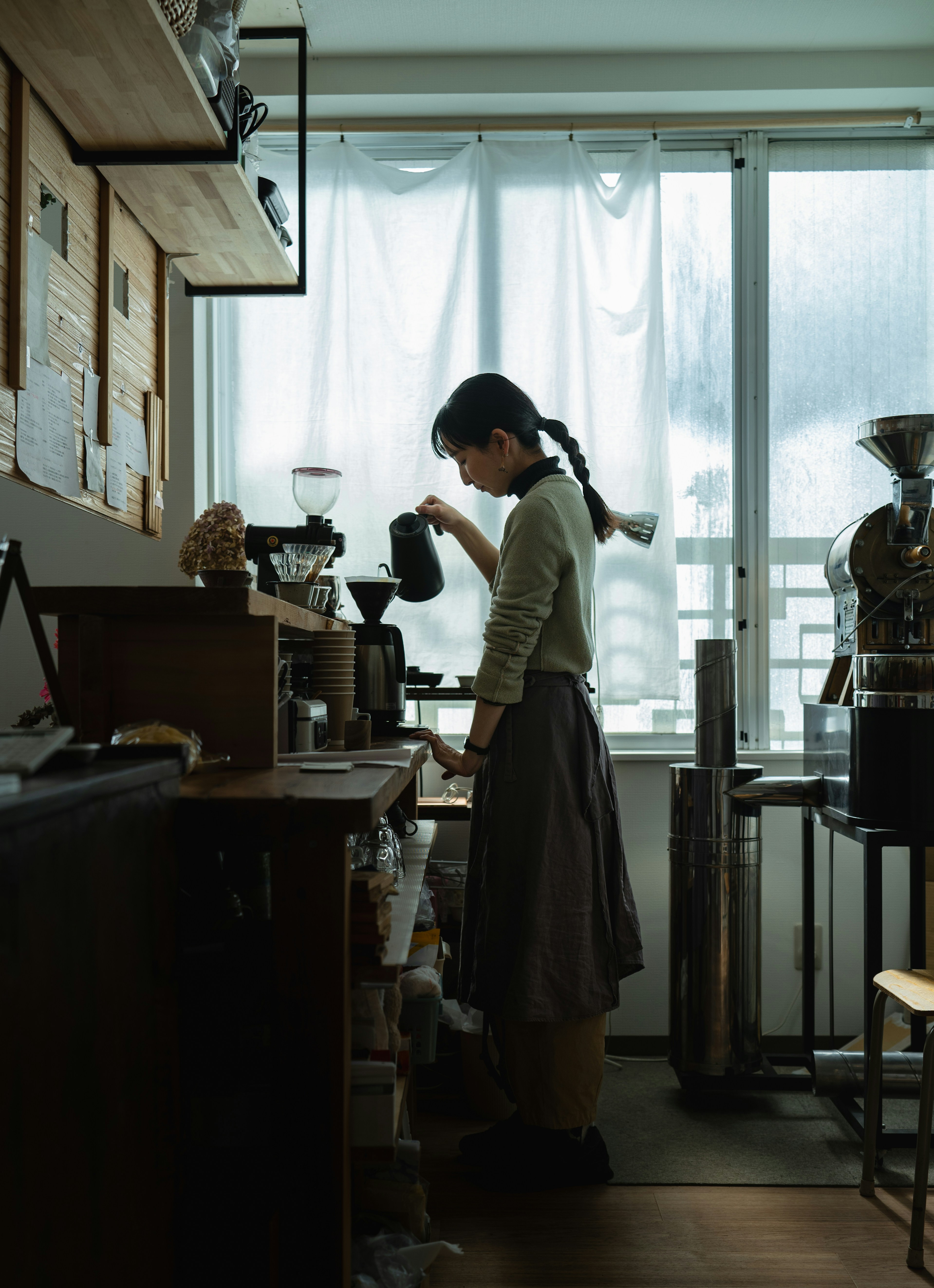 A woman standing in a kitchen next to a window