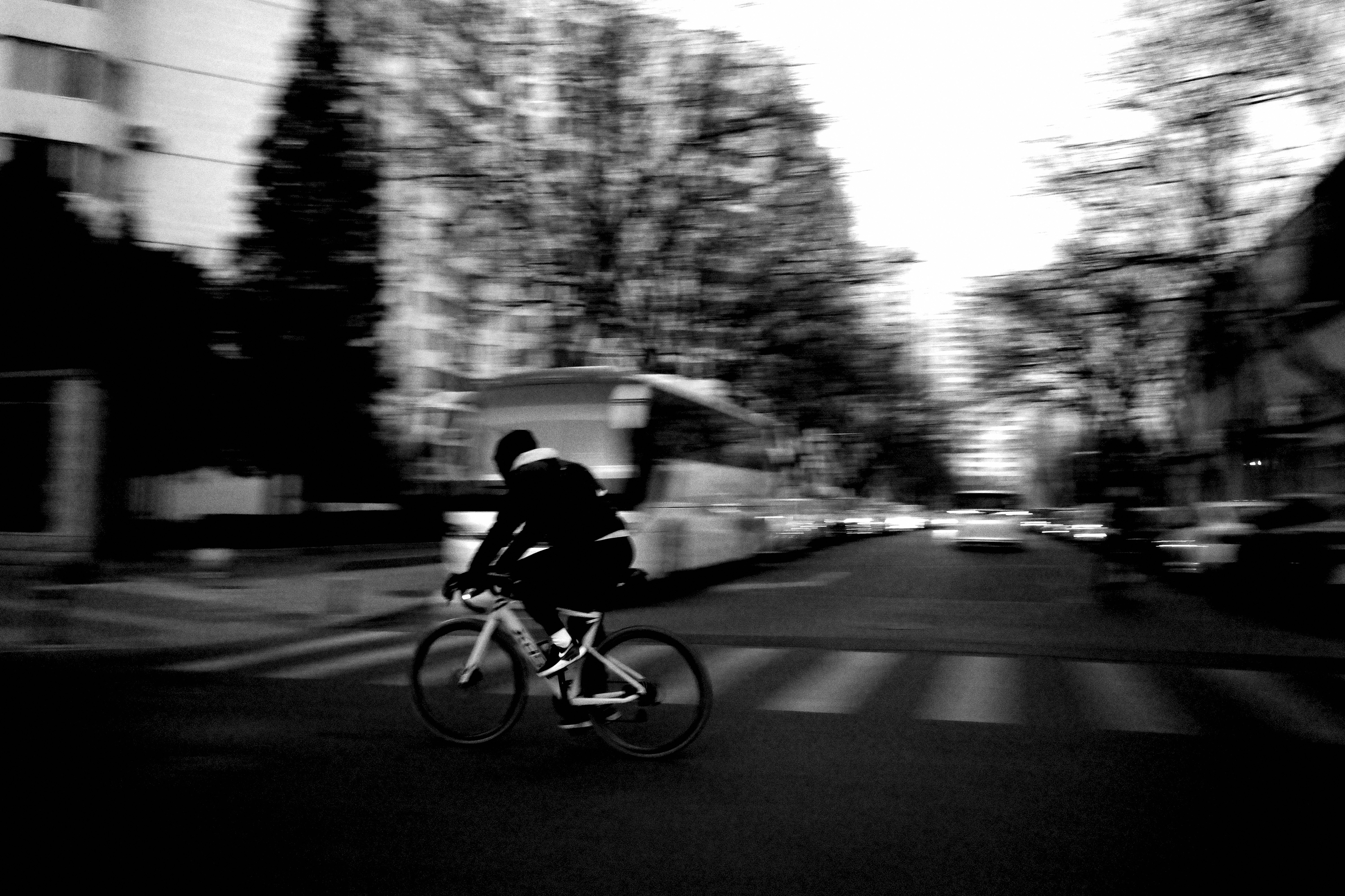 A man riding a bike down a street next to tall buildings