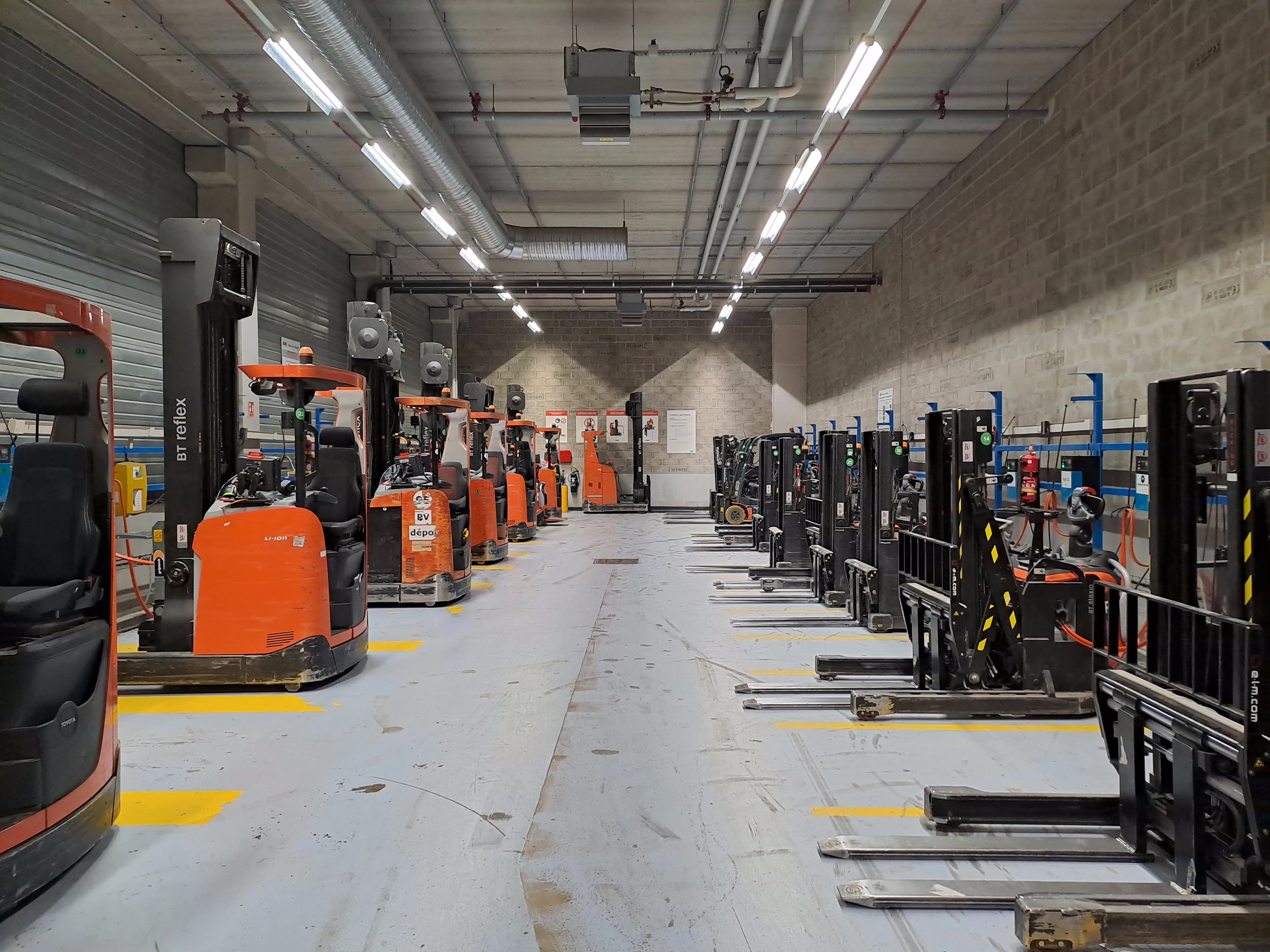 A large warehouse floor with rows of material-handling equipment