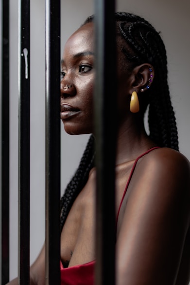 A woman standing behind bars in a jail cell