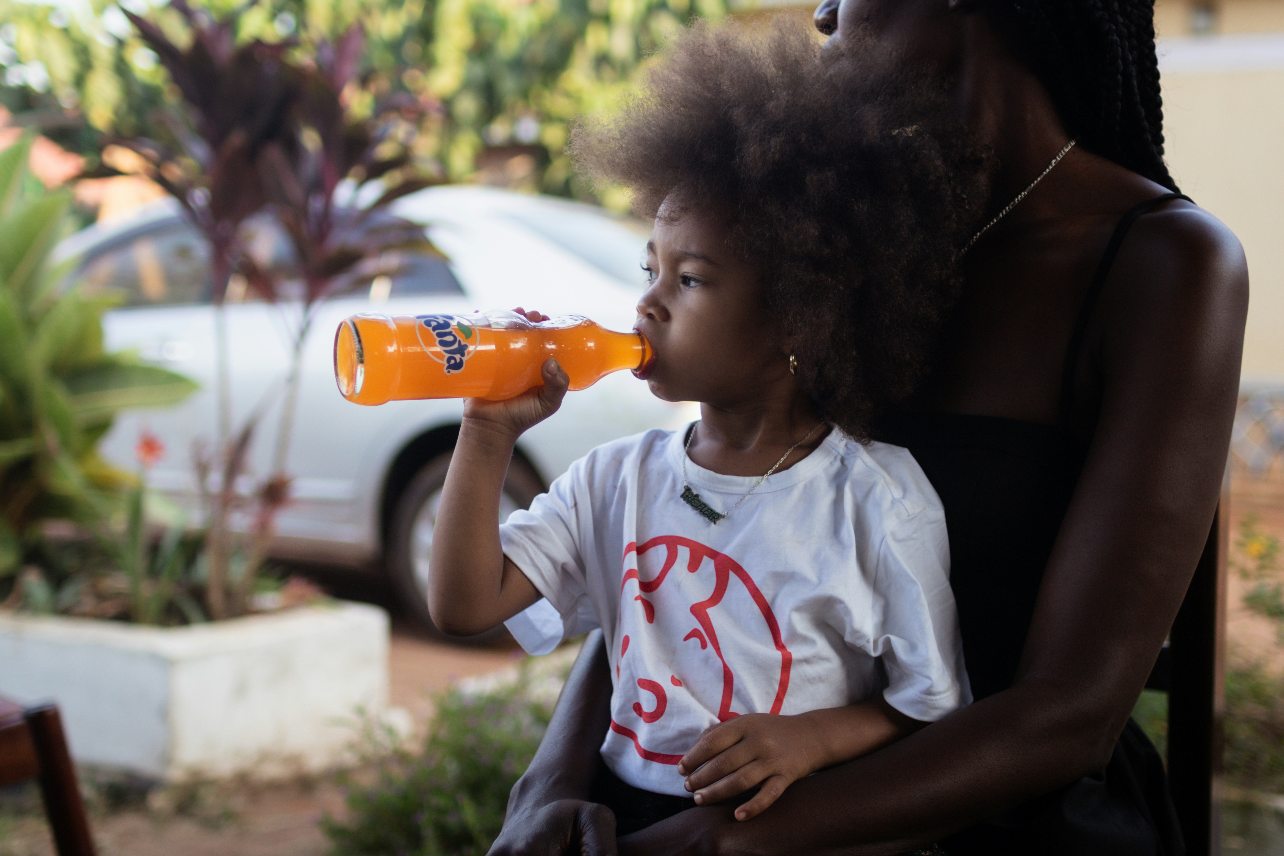 A woman sitting in a chair drinking from a bottle