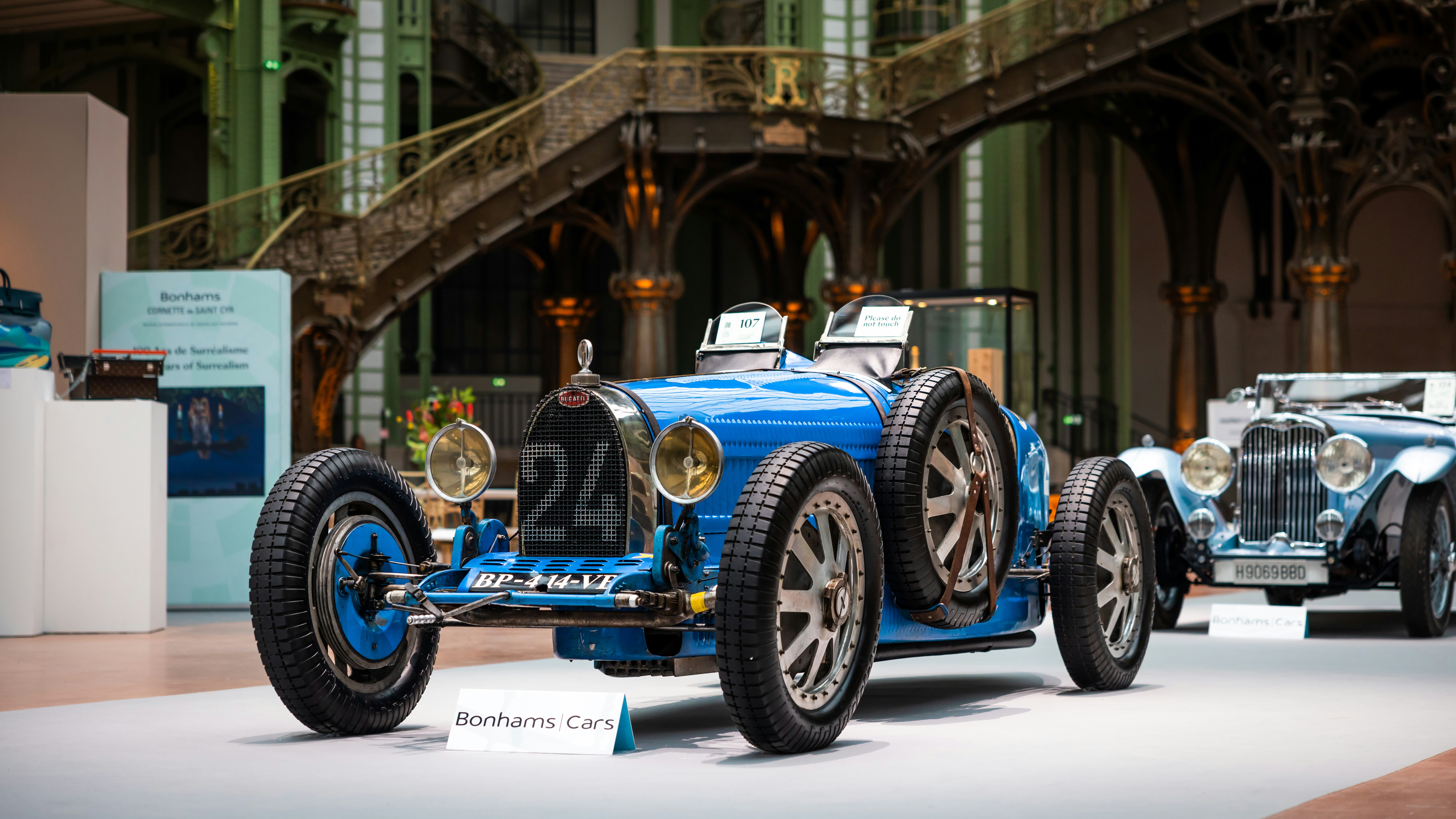 A blue car is on display in a museum