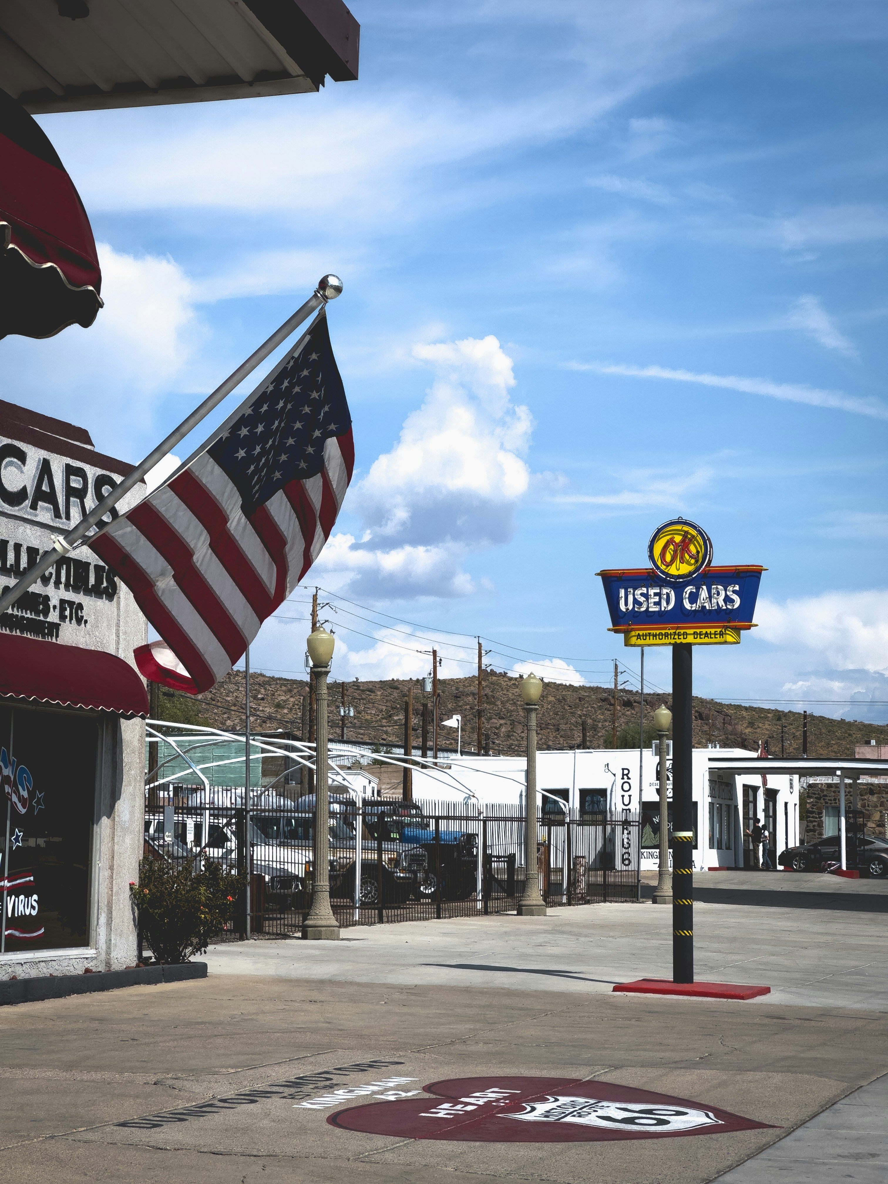 A car dealership with an american flag hanging from the roof