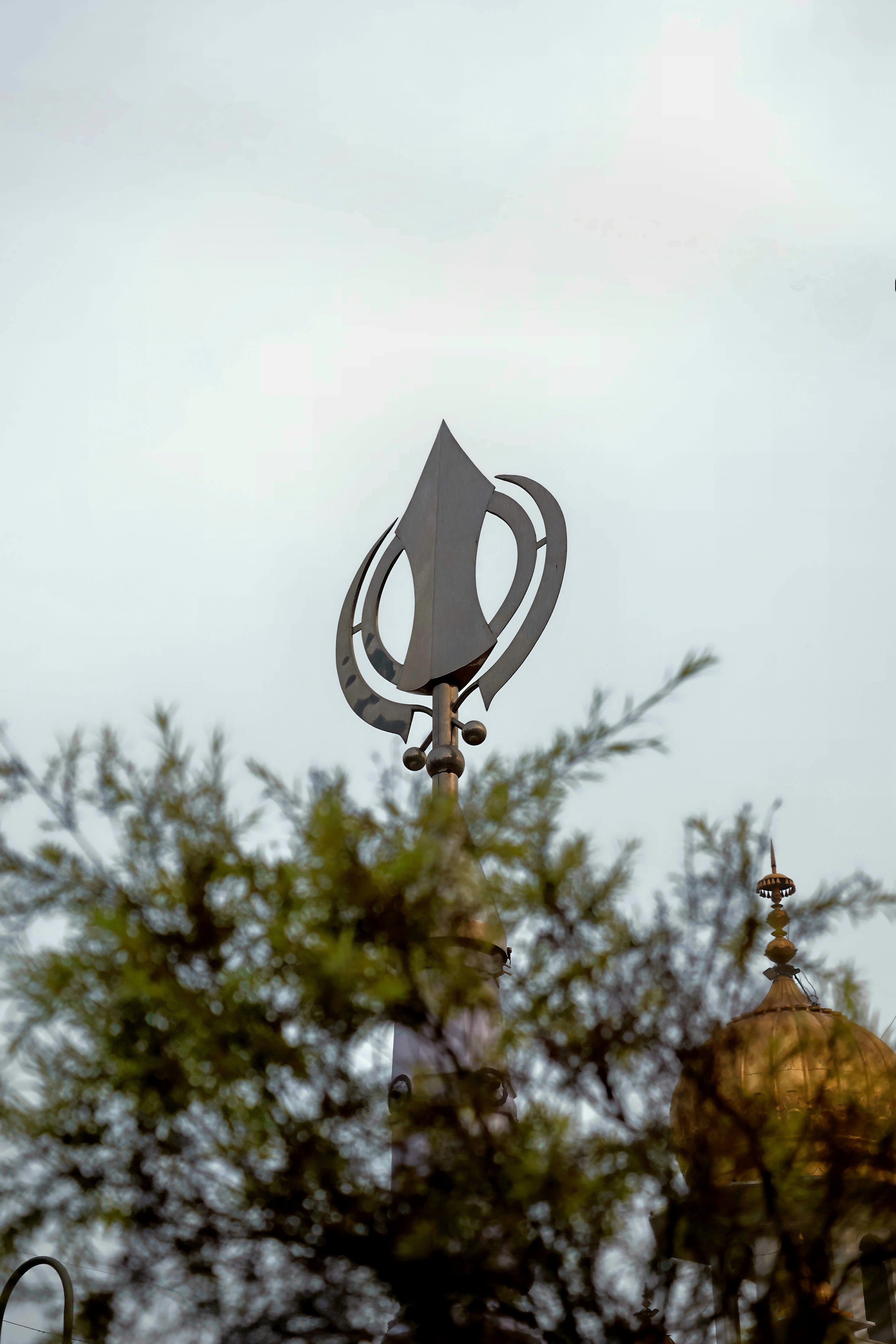 A clock tower with a weather vane on top of it