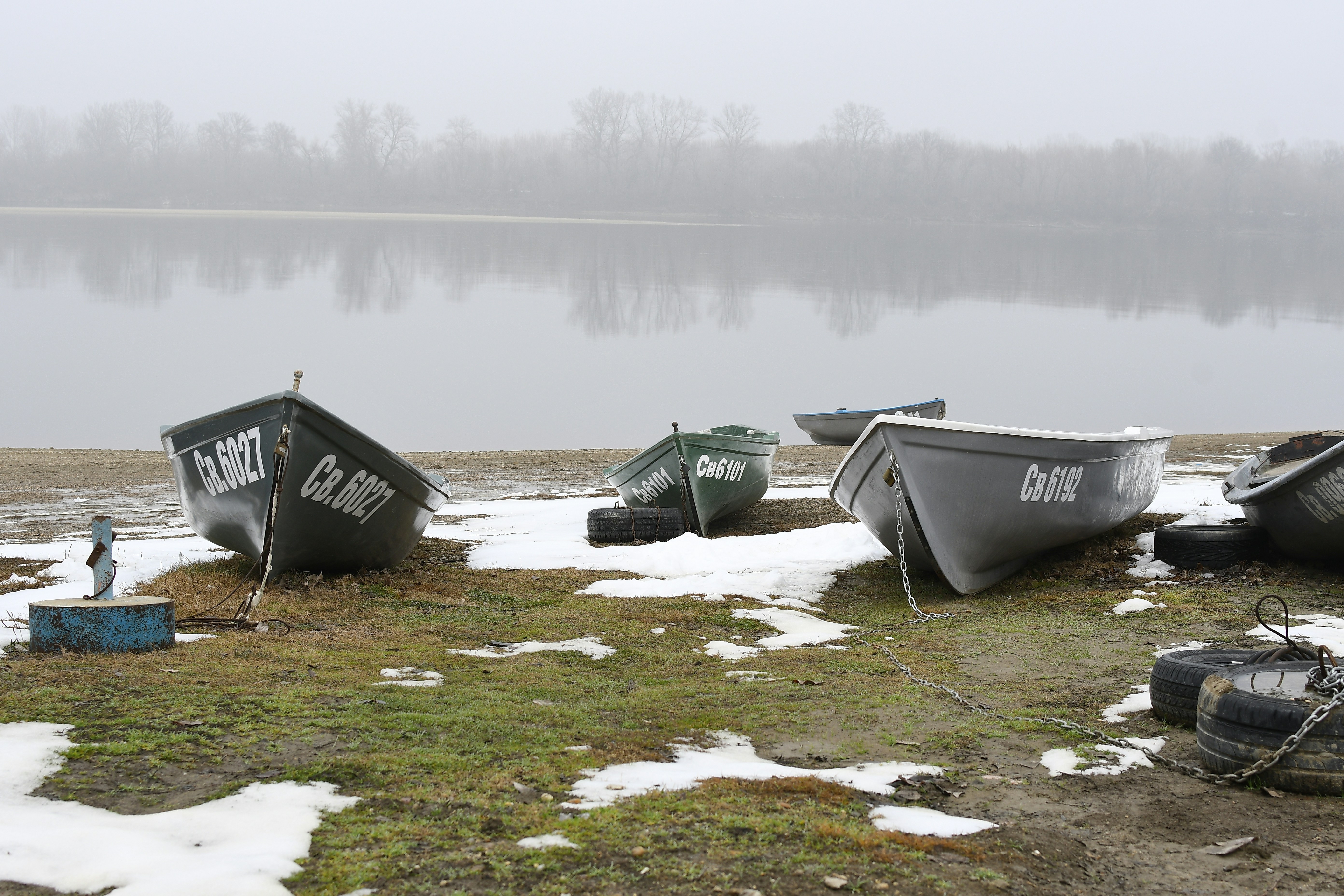 A group of boats sitting on top of a snow covered field