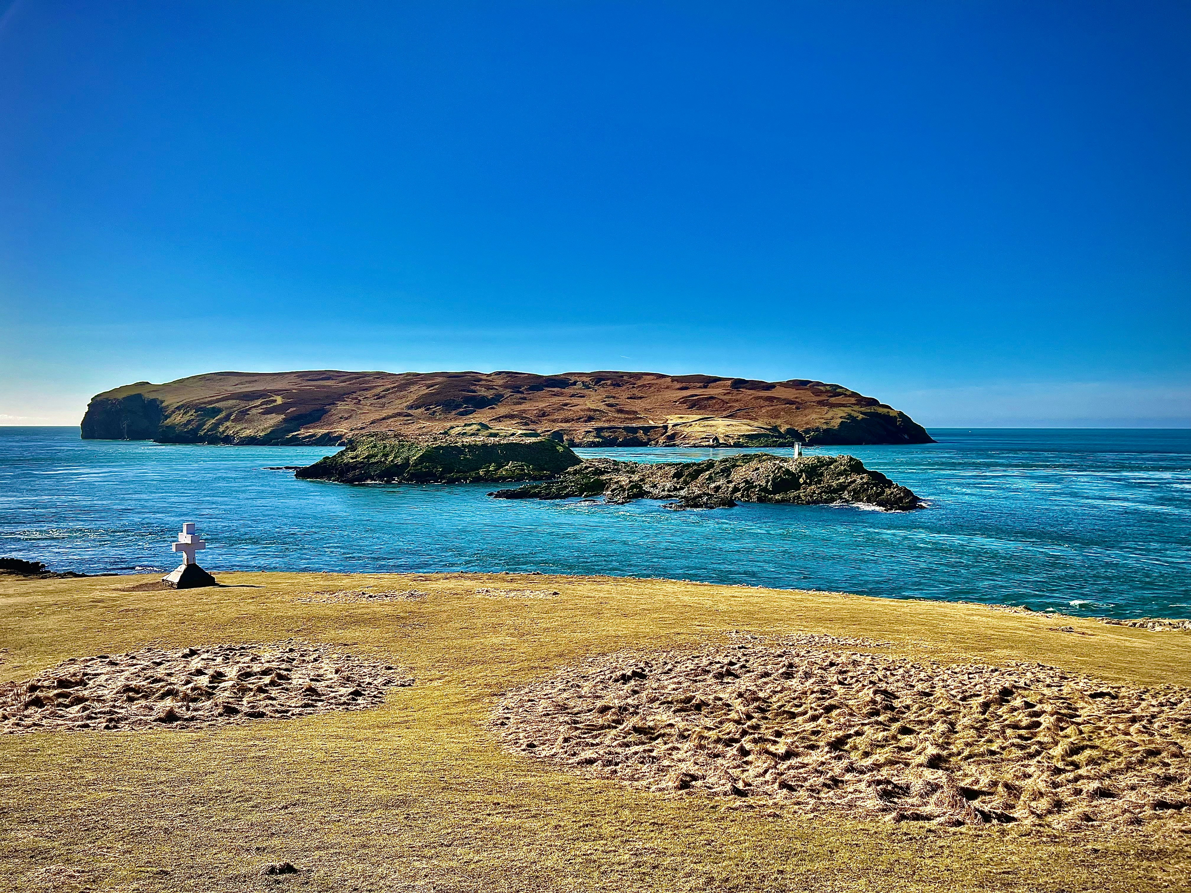A person sitting on a rock looking out at the ocean