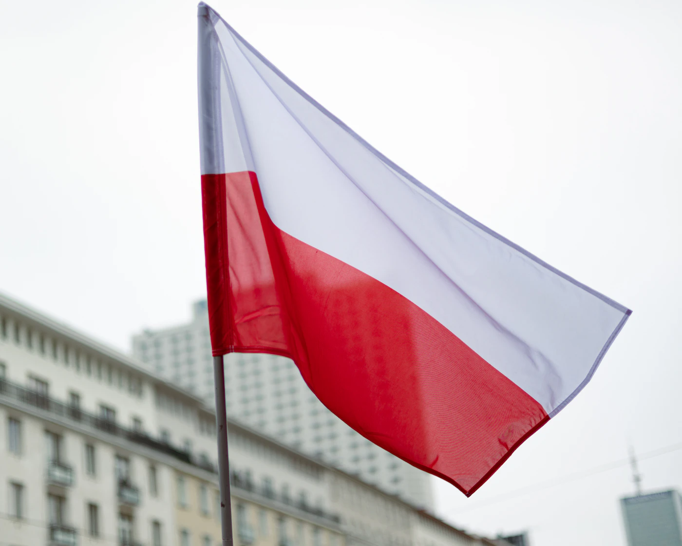 A red and white flag flying in the wind.