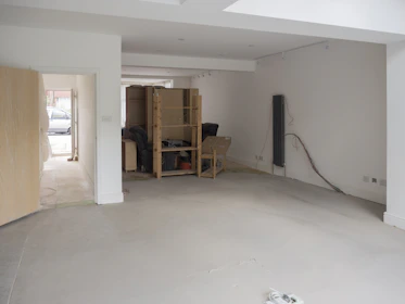 An empty room with a white wall and a wooden door