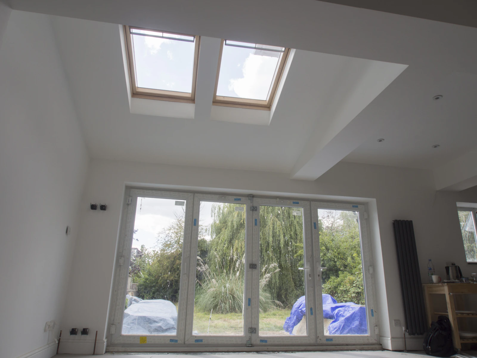 Extension interior at second fix stage with two roof windows and folding doors