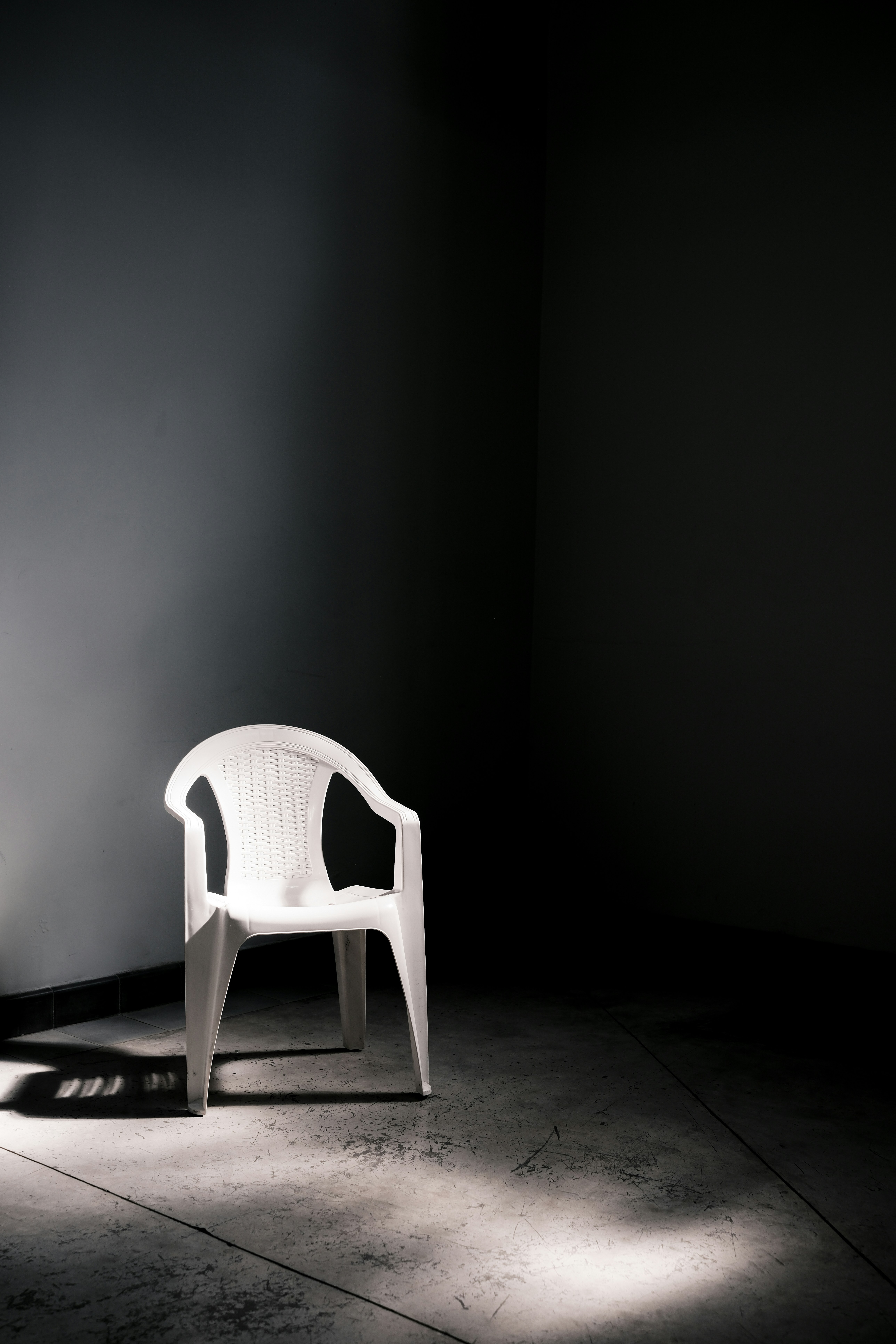 A white chair sitting in a dark room